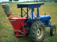 Farmer driving a tractor with a vehiclespreader
