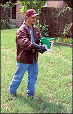 a man gets ready to apply bait to an ant mound